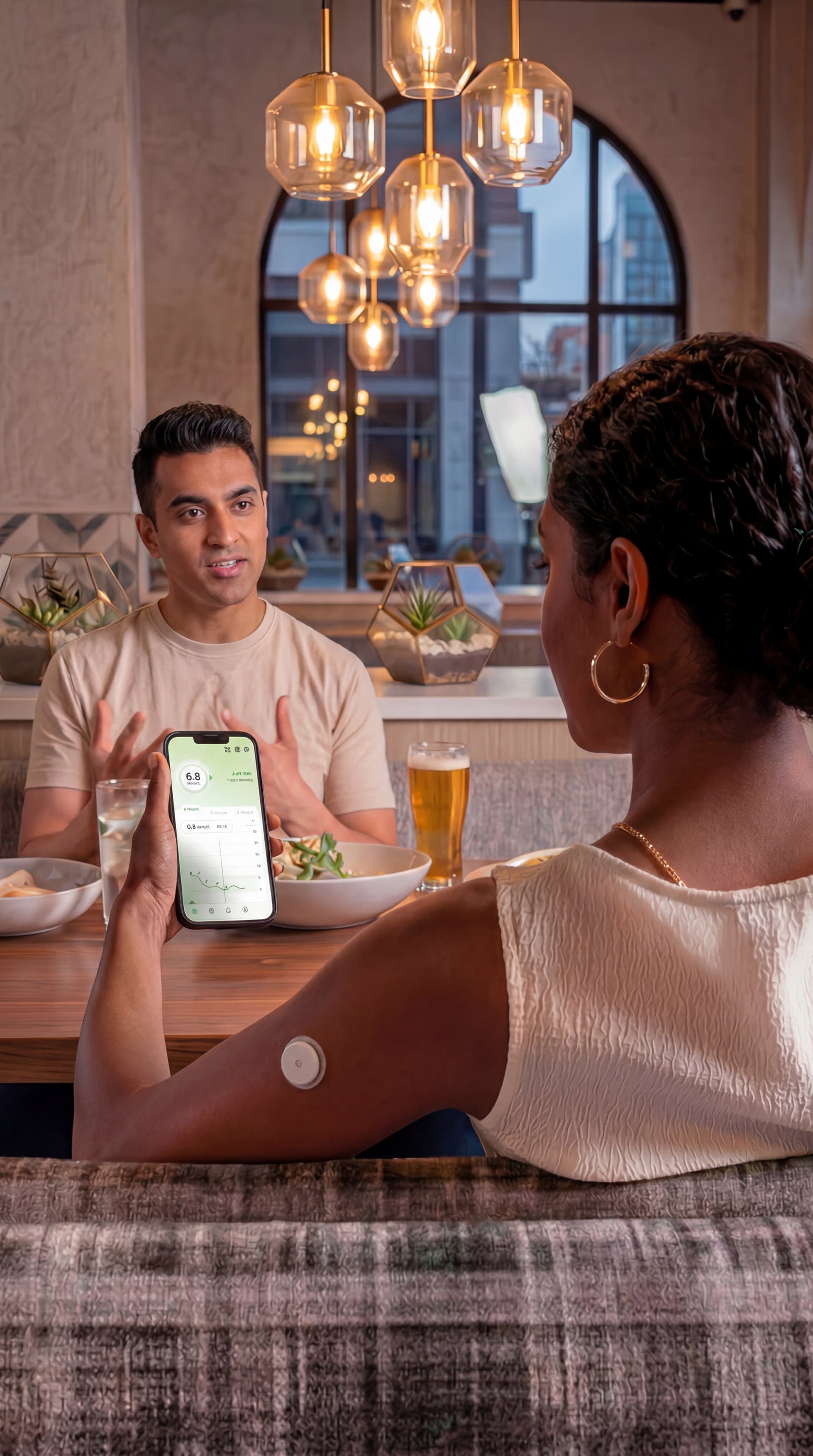Couple checking live glucose readings on phone at restaurant