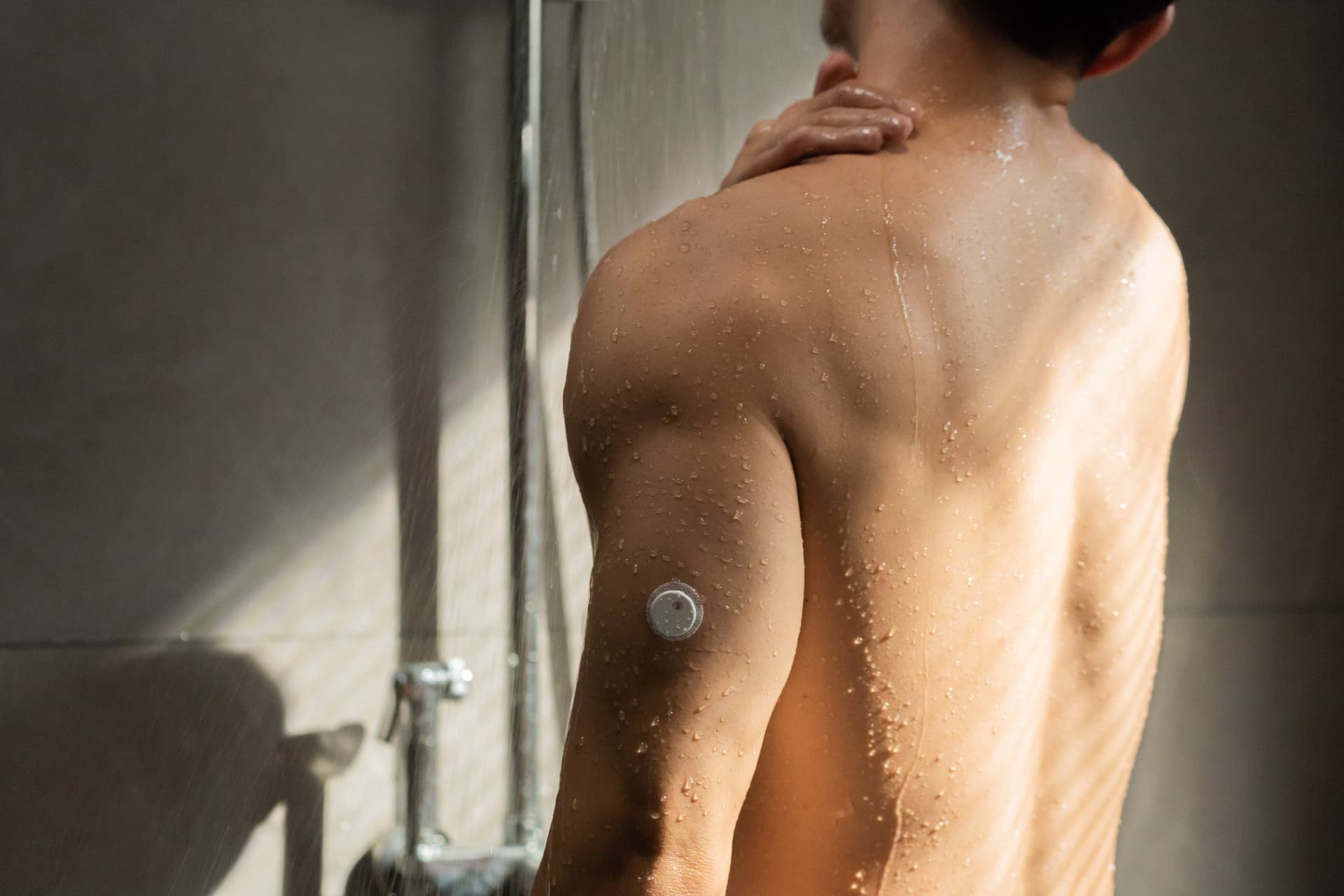 Person showering while wearing the waterproof Vixxa 2 CGM sensor